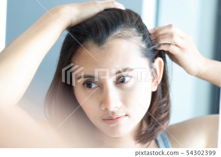 Woman looking reflection in the mirror serious Woman looking reflection in the mirror serious 54302399