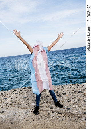 person covered with a transgender pride flag 54302475
