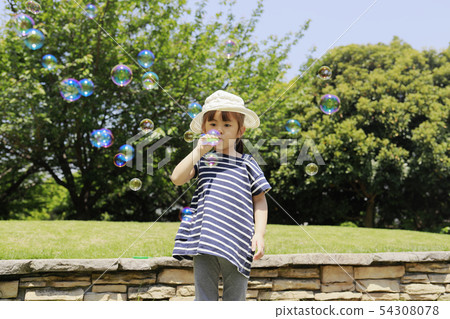 Toddler (4 years old) and blue sky playing with soap bubbles Toddler (4 years old) and blue sky playing with soap bubbles 54308078