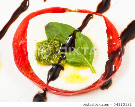 mozzarella and tomato slices with basil close up 54310181