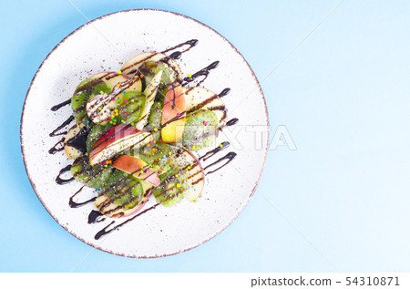 Tasty fruit salad on bright pastel background Tasty fruit salad on bright pastel background 54310871