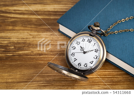 Vintage pocket watch clock with book on wooden Vintage pocket watch clock with book on wooden 54311668