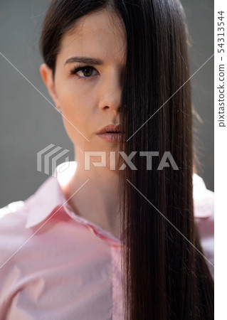 Brunette with very beautiful hair in a pink shirt 54313544