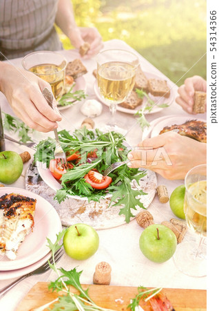 People eat in the garden at the table. Dinner People eat in the garden at the table. Dinner 54314366