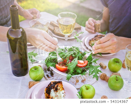 People eat in the garden at the table. Dinner People eat in the garden at the table. Dinner 54314367
