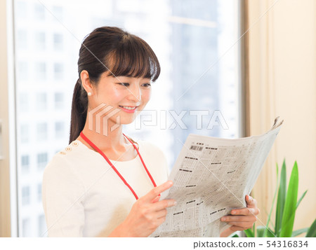 Business woman looking at newspaper stock column 54316834