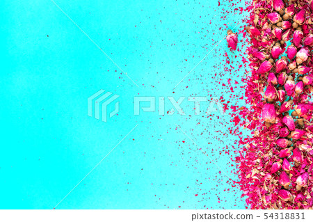 Dried buds of pink roses on a blue background. Place for text.  54318831