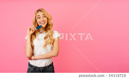 Cheerful Woman Holding Bank Card And Looking Away 54319728