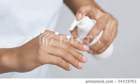 Skin Care Concept. Woman Pumping Out Lotion Skin Care Concept. Woman Pumping Out Lotion 54319761
