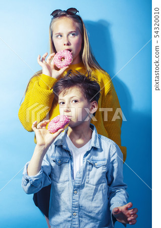happy family brother and sister eating donuts on blue background, lifestyle people concept, boy and happy family brother and sister eating donuts on blue background, lifestyle people concept, boy and 54320010