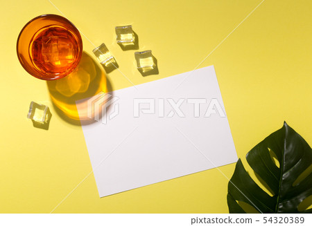 Refreshing cocktail with ice cubes on yellow background 54320389