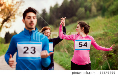 A group of multi generation people running a race competition in nature. 54325155