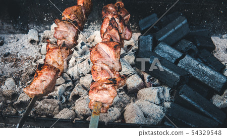 The meat is on charcoal close-up outdoors. Street 54329548