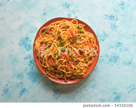 Schezwan Noodles with vegetables in a plate.  54330106
