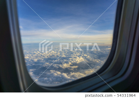 Aerial view sky and clouds through the plane illuminator after aircraft take off. 54331964