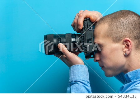 Male photographer examining his new camera Male photographer examining his new camera 54334133