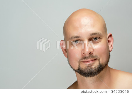 Attractive smiling bald man on gray background - Stock Photo