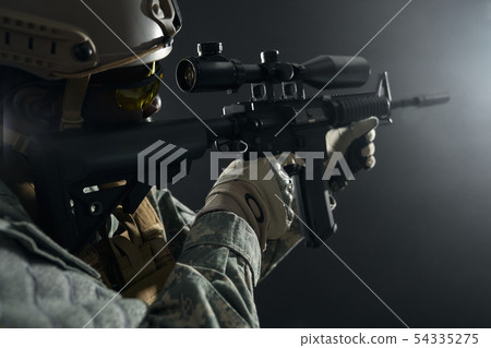 African professional soldier shooting from modern long gun. African professional soldier shooting from modern long gun. 54335275