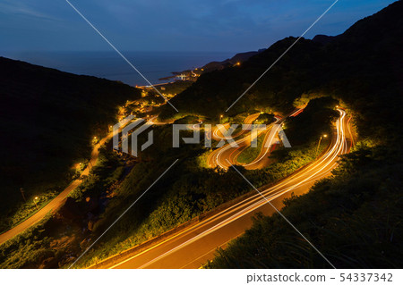 Aerial view of cars driving on curved, zigzag road Aerial view of cars driving on curved, zigzag road 54337342