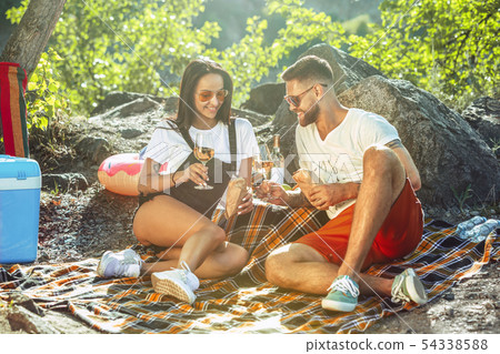 Young couple having picnic at riverside in sunny day 54338588