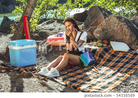 Young couple having picnic at riverside in sunny day 54338589
