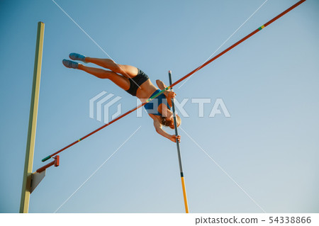 Female high jumper training at the stadium in sunny day Female high jumper training at the stadium in sunny day 54338866