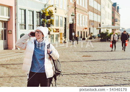 Caucasian tourist girl uses phone, hand calling smartphone on Copenhagen Nyhavn, Europe well known 54340170