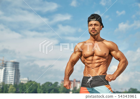 Handsome muscular bodybuilder posing over black background. Stock Photo |  Adobe Stock