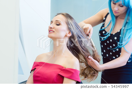 Woman hairdresser styling hair of customer in her shop 54345997
