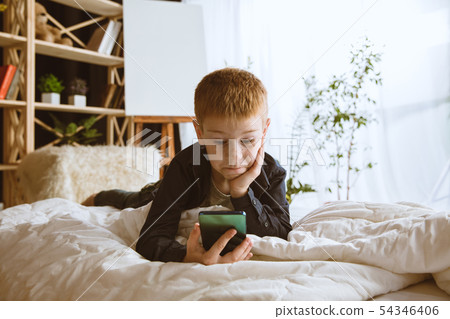 Little boy using different gadgets at home 54346406