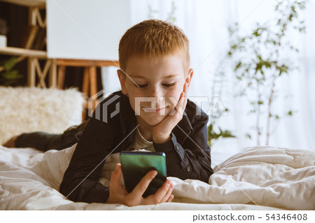 Little boy using different gadgets at home 54346408