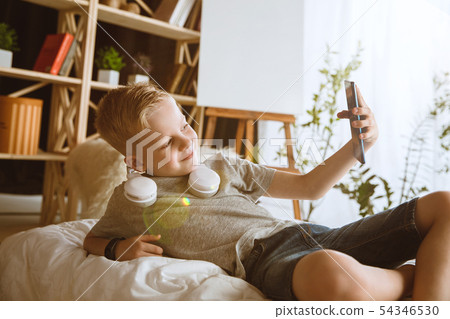 Little boy using different gadgets at home Little boy using different gadgets at home 54346530
