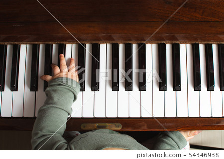 Baby's hands playing a piano, finger Baby's hands playing a piano, finger 54346938