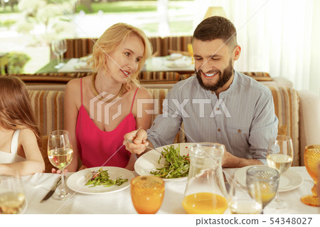Handsome bearded husband treating his wife giving her some salad Handsome bearded husband treating his wife giving her some salad 54348027