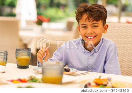 Handsome boy smiling while enjoying breakfast 54348550