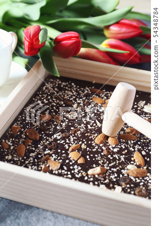 Dark handmade chocolate with nuts and red tulips 54348784