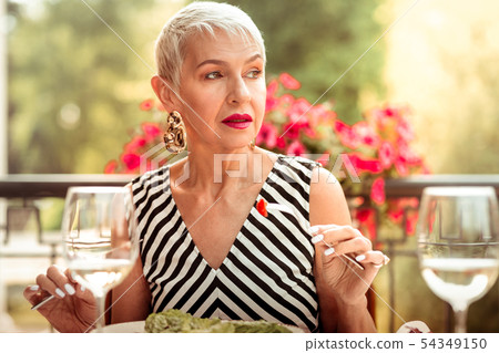 Woman with nice makeup eating salad for dinner outside Woman with nice makeup eating salad for dinner outside 54349150