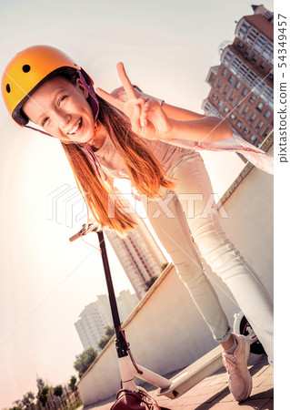 Positive young lady in yellow protective helmet exposing her feeling Positive young lady in yellow protective helmet exposing her feeling 54349457