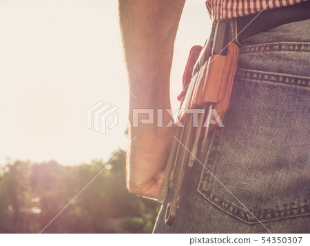Male hand, blue jeans and vintage belt Male hand, blue jeans and vintage belt 54350307