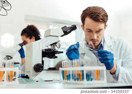 Smart young man working as a biologist Smart young man working as a biologist 54350537