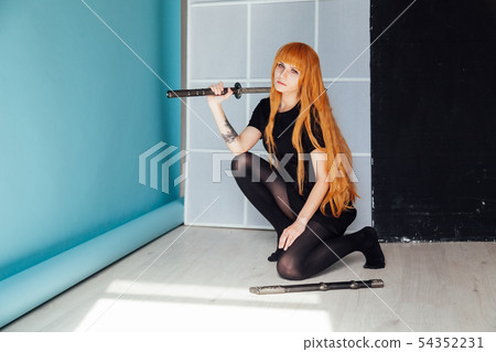 young woman in japanese anime cosplay, holding samurai sword. 54352231