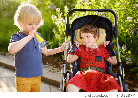 Little boy and a disabled girl playing together in Little boy and a disabled girl playing together in 54352877