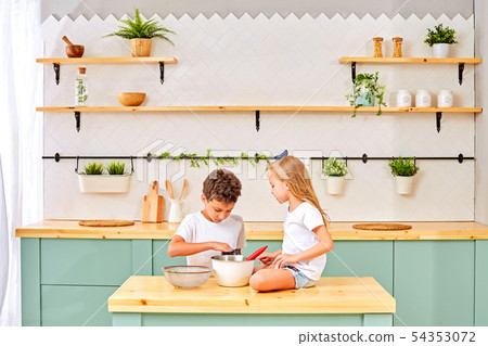 Children are cooked and played with flour and dough in the kitchen 54353072