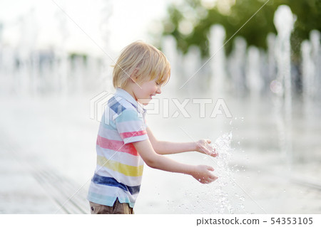 Little boy plays in the square between the water Little boy plays in the square between the water 54353105