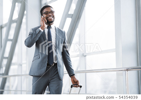 Always in Touch. Busy Man Talking on Phone in Airport Always in Touch. Busy Man Talking on Phone in Airport 54354039