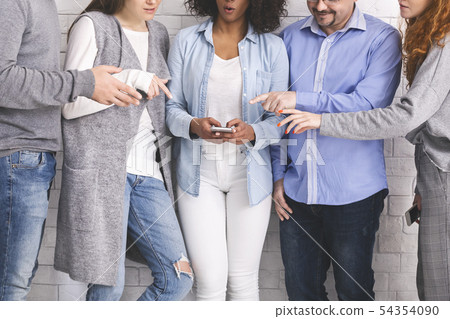 Group of millennials reaching hands to cellphone Group of millennials reaching hands to cellphone 54354090