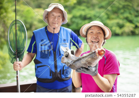 happy Senior couple fishing at the lakeside 54355287