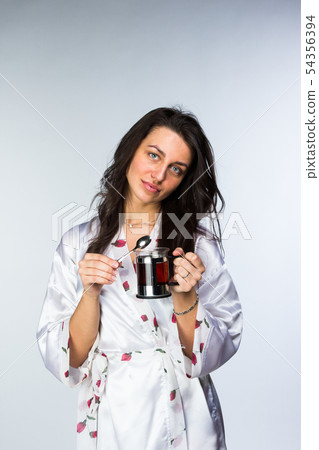 Woman with cup of tea in peignoir early morning 54356394