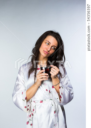 Woman with cup of tea in peignoir early morning 54356397