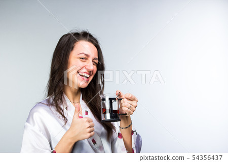 Woman with cup of tea in peignoir early morning 54356437